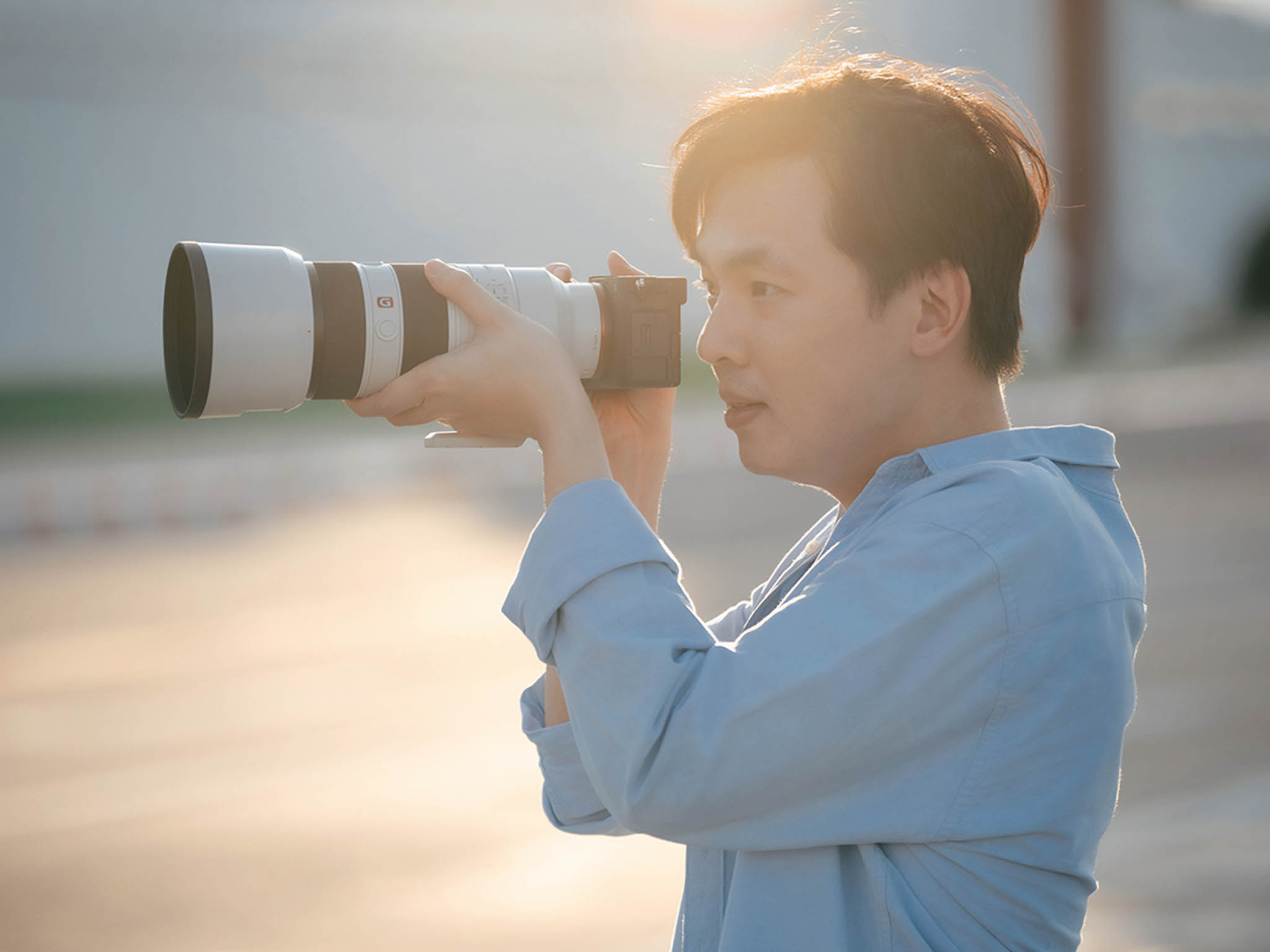 ผู้ก่อตั้ง PhotoPlease ถือกล้องถ่ายภาพ