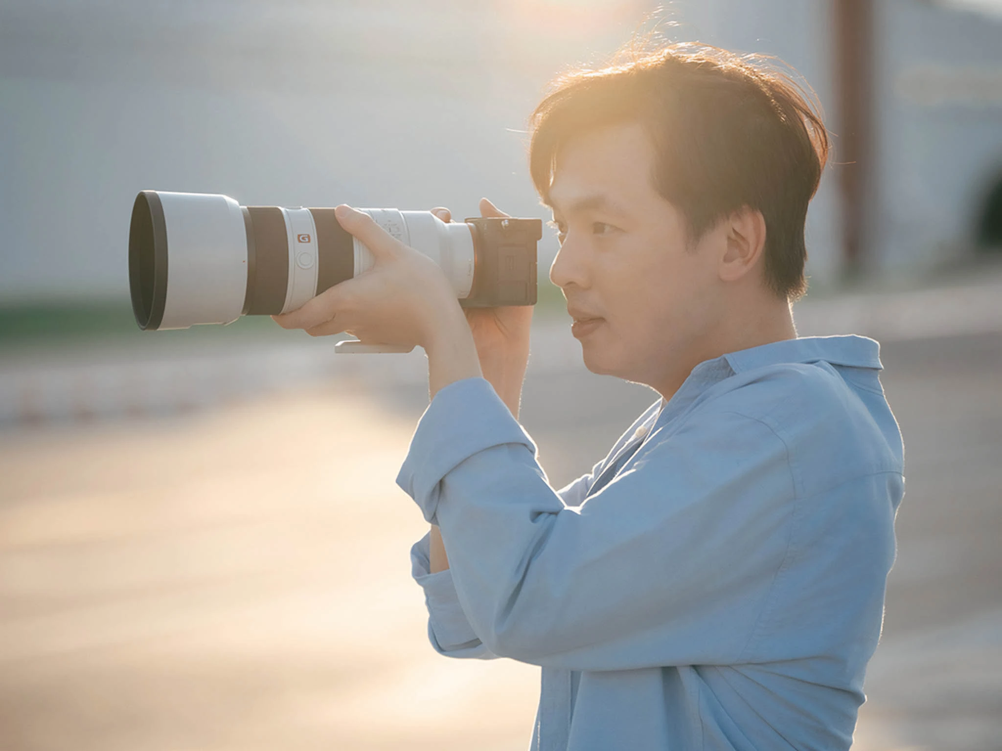 ผู้ก่อตั้ง PhotoPlease ถือกล้องถ่ายภาพ